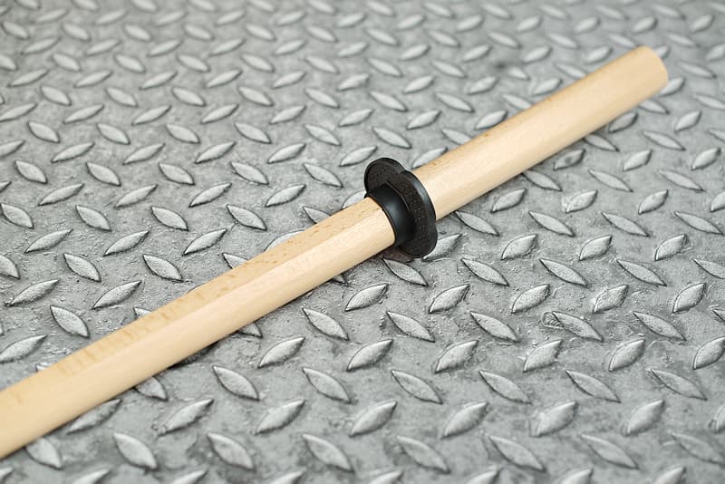 Bokken (木剣 katana de entrenamiento de madera, bokutō (木刀) en Japón), con tsuba sujeta por una anilla elástica.