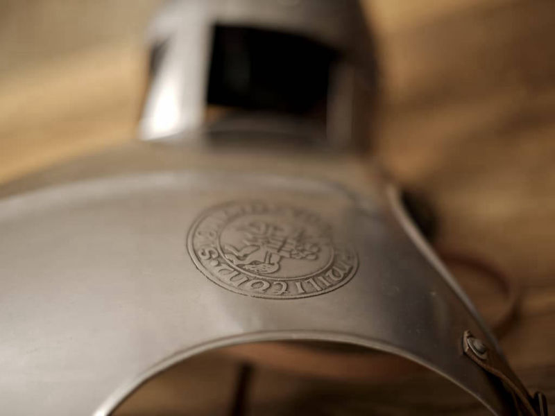 Peto templario sobre una mesa medieval con casco de caballero Peto templario sobre una mesa medieval con casco de caballero