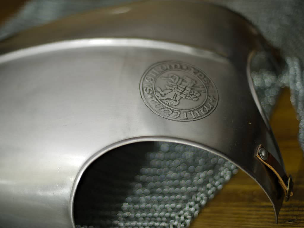 Peto templario sobre una mesa medieval y cota de malla de caballero Peto templario sobre una mesa medieval y cota de malla de caballero