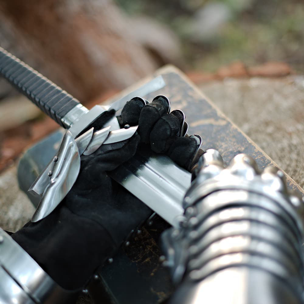 Espada "Fidelis": frapa medievalPar de guanteletes articulados de acero con escamas cosidas sobre cuero negro muy flexible, pomo en cruz facetado, vaina con cordones