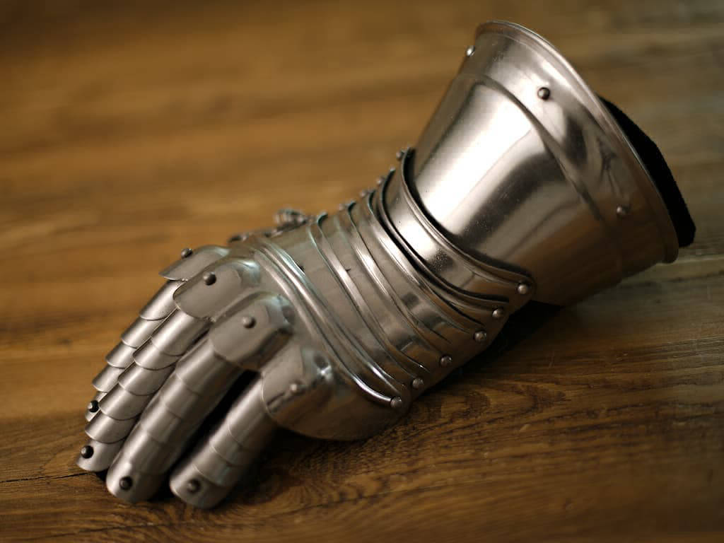 Guantelete articulado sobre una mesa medieval de madera