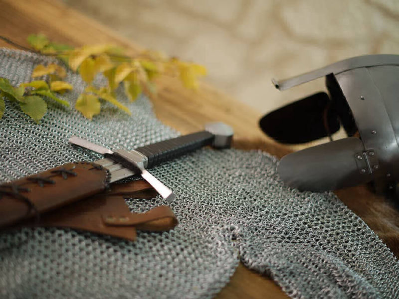 Cota de malla medieval con casco y espada de combate Cota de malla medieval con casco y espada de combate