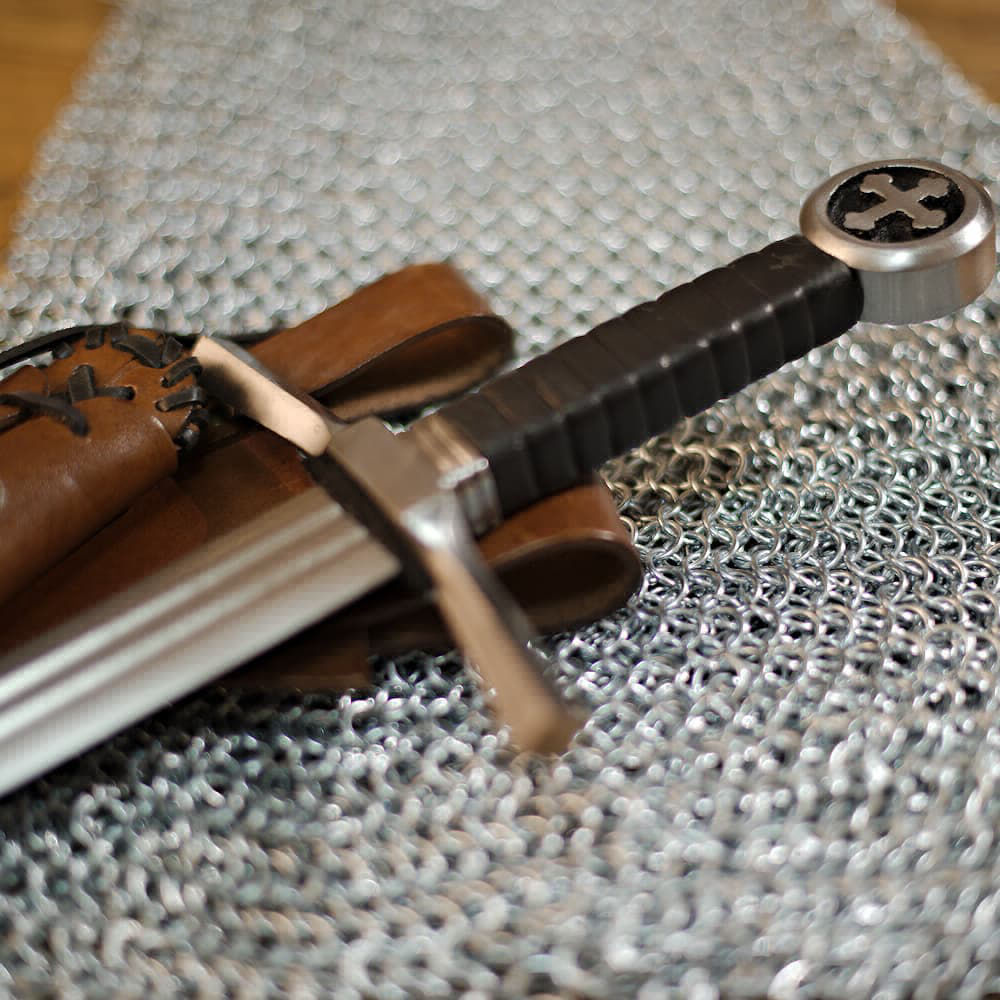 Espada medieval de caballero cruzado (espada de golpear con pomo de cruz trilobulada y vaina de cuero marrón con cordones, inclinada)