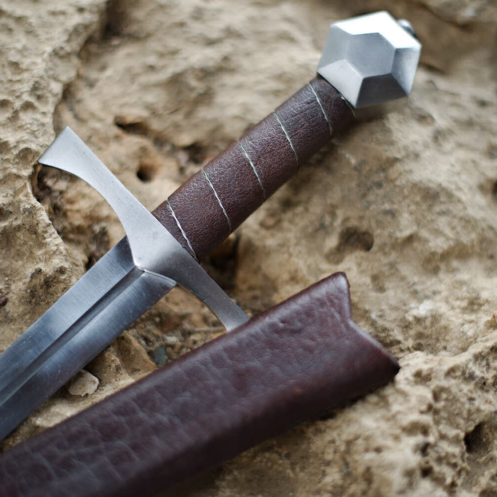 Daga de combate medieval "Lightbane" apoyada en una roca