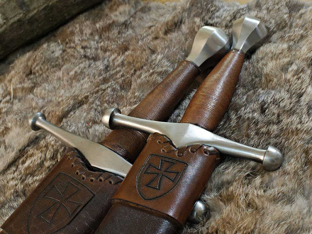 Épée et dague médiévale allemande, posées sur une peau naturelle Épée et dague médiévale allemande, posées sur une peau naturelle