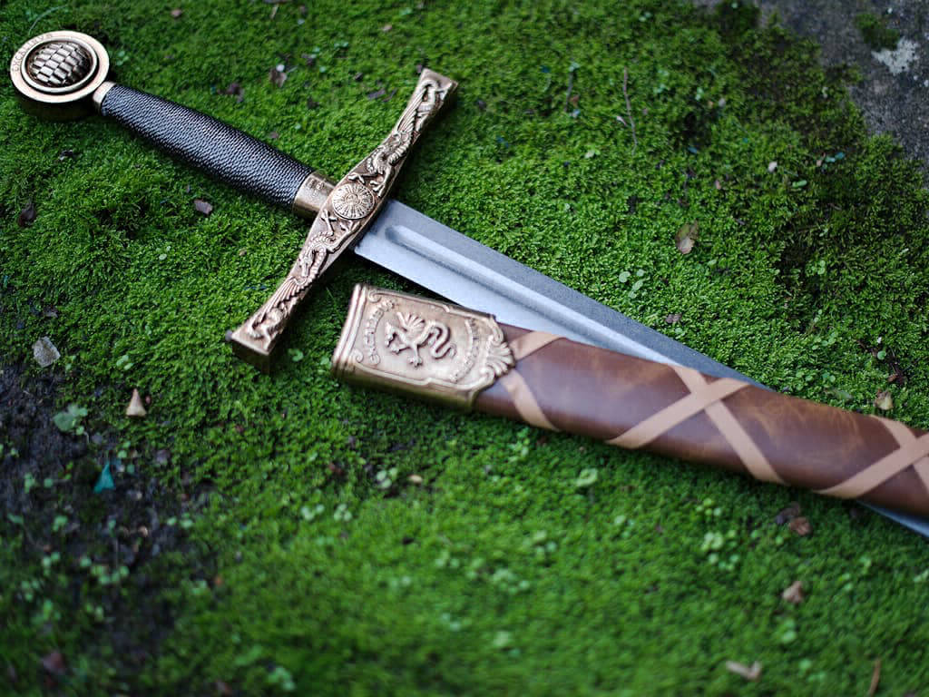 L'épée Excalibur, arme de légende du roi Arthur, posée sur une pierre recouverte de mousse naturelle L'épée Excalibur, arme de légende du roi Arthur, posée sur une pierre recouverte de mousse naturelle