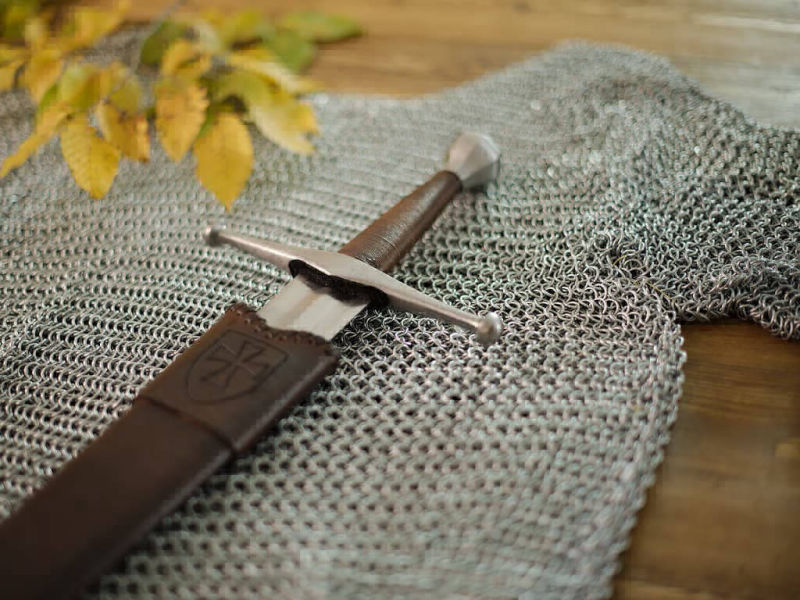 Épée médiévale de combat posée sur la cotte de mailles Épée médiévale de combat posée sur la cotte de mailles