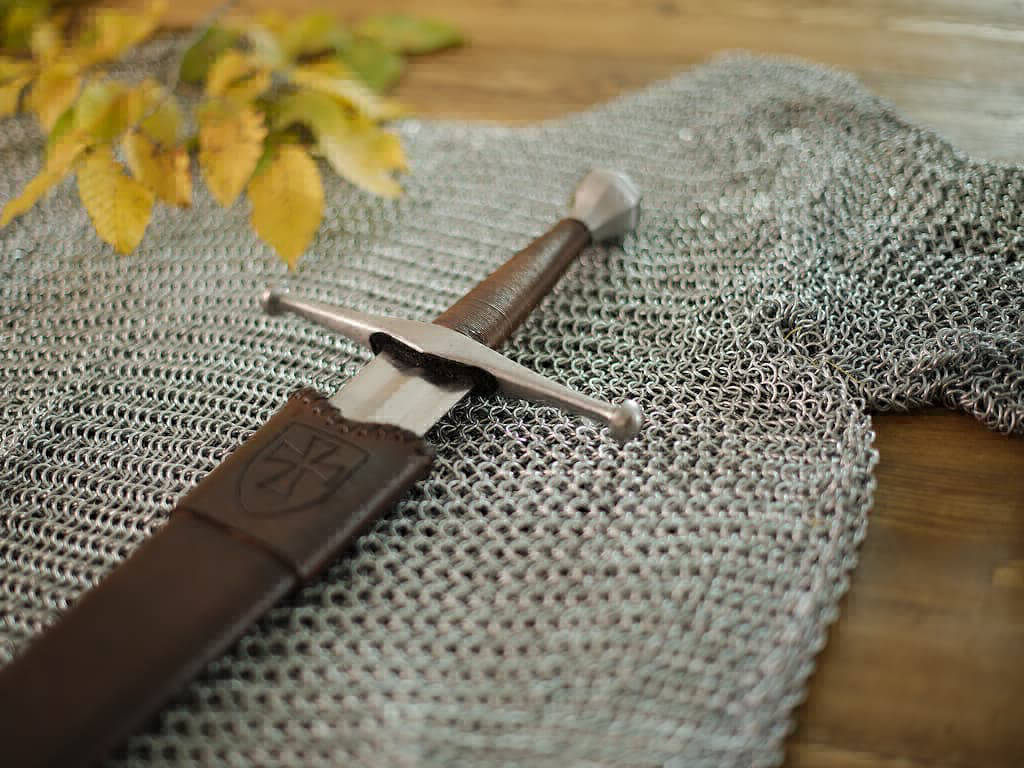 Épée médiévale de combat posée sur la cotte de mailles Épée médiévale de combat posée sur la cotte de mailles
