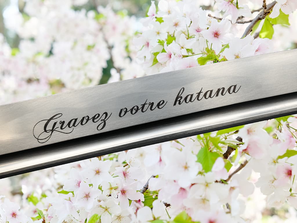 Grabado por láser en la hoja de una katana: la frase "Gravrz votre katana" (Grabe su katana) en una bonita fuente de carcatères desatadas #Terressens Grabado por láser en la hoja de una katana: la frase "Gravrz votre katana" (Grabe su katana) en una bonita fuente de carcatères desatadas #Terressens